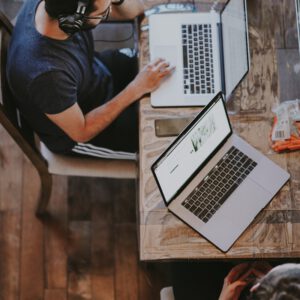 man sitting on chair and looking laptop computer